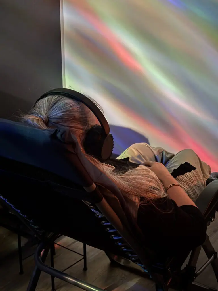 Guest relaxing in the Aurora Room at a wellness spa in Stratford with sound and light therapy for deep relaxation
